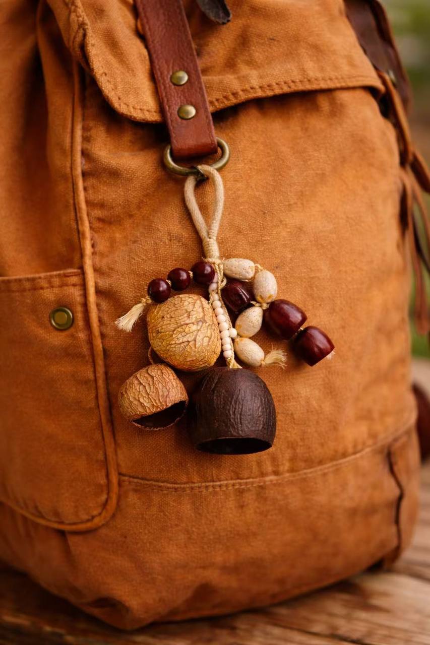 Brown leather bag with a decorative acorn charm on a wooden surface